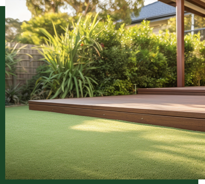 Wooden Deck with Artificial Grass Wooden deck surrounded by artificial grass, lush greenery and plants, showcasing a natural outdoor setting with vibrant foliage.